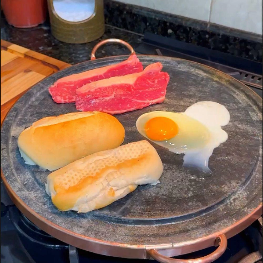 Frigideira de pedra-sabão selando carne, ovo e pão